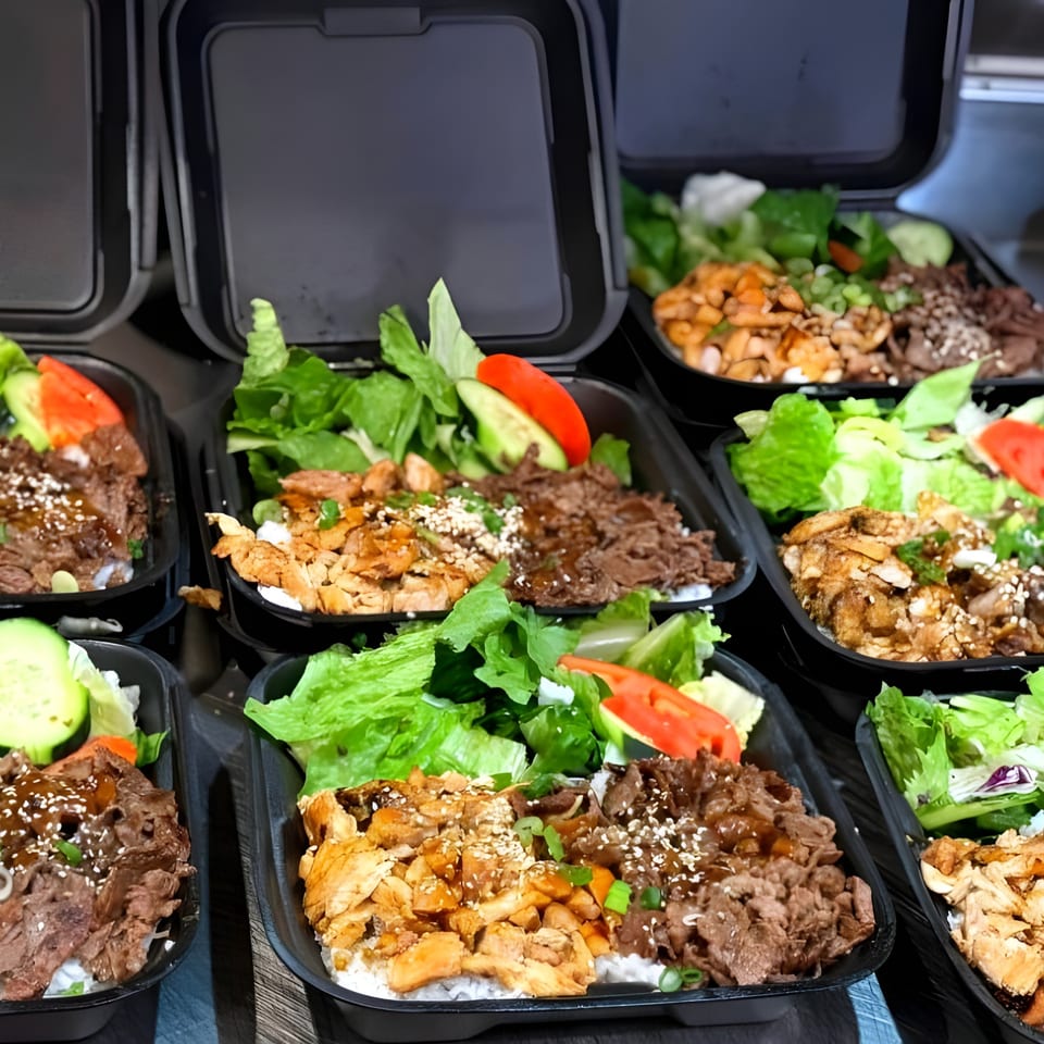Multiple Ronin BBQ Teriyaki bento boxes with chicken, beef, rice, and fresh salad.