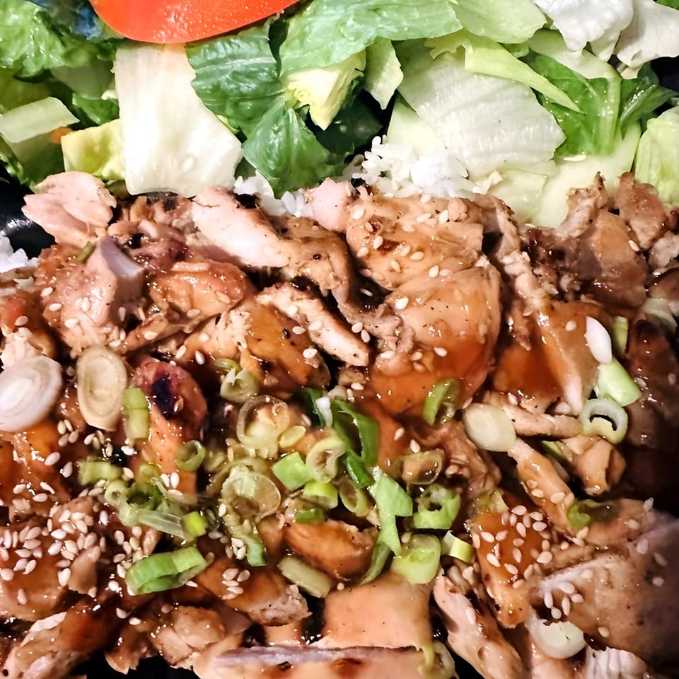 Ronin BBQ Teriyaki chicken with sesame seeds, green onions, and a side salad.